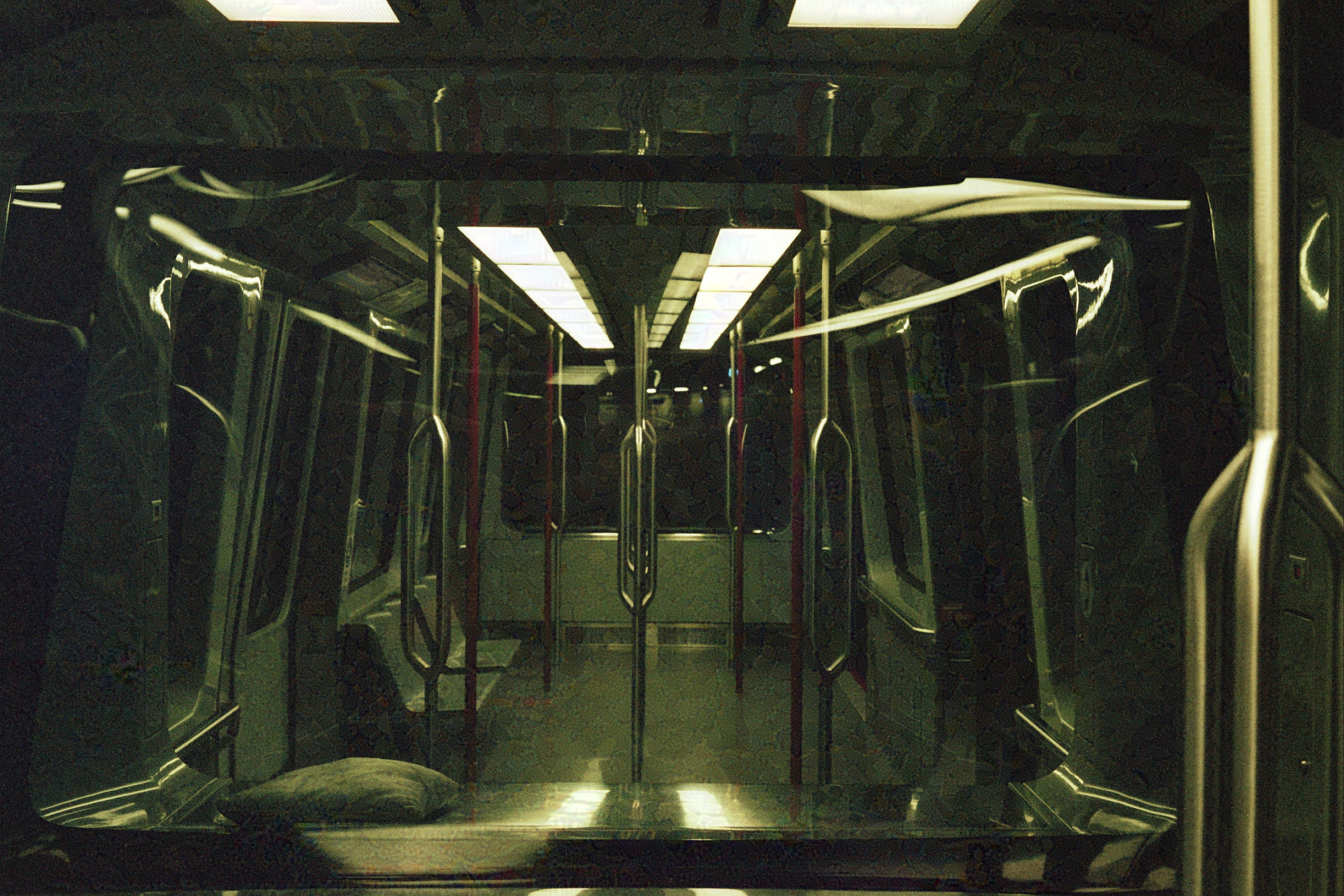Empty subway car at night with overhead fluorescent lighting