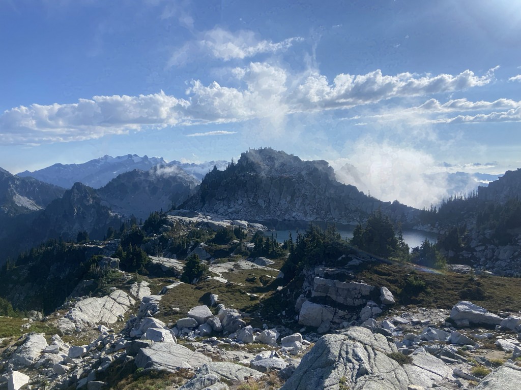Alpine lake and jagged granite peaks with clouds drifting across the ridgeline